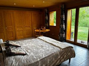 a bedroom with a bed and a table and windows at Le cocon alpin in Passy
