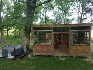 a tiny house in the woods with a tree at Le chalet de Montestrucq in Montestrucq