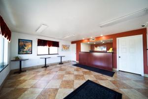 a waiting room with two tables and a door at Superior Suites Phoenix Mesa in Mesa