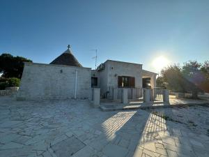 a house with a fence and a stone patio at Trullo Cuore di Pietra in Locorotondo
