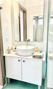 a white bathroom with a sink and a mirror at Hayeks Villa private pool near the beach in Daratso