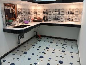 a kitchen with a sink and a tiled floor at Dream Mahal in Kattankudi