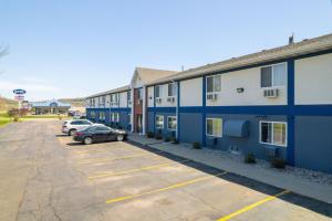 a row of buildings with a car parked in a parking lot at Days Inn by Wyndham Sioux City in Sioux City