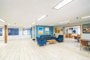 a waiting room with blue furniture and a table at Days Inn by Wyndham Sioux City in Sioux City +64 photos