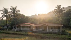 a row of houses with palm trees in the background at Amra Woods in Karjat