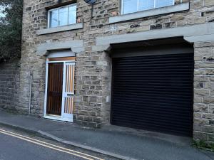 a brick building with two garage doors on it at Hollins Mill Apartment in Sowerby Bridge