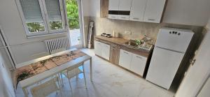 a kitchen with a white refrigerator and a table at Ira's Square 2 Bedroom Free Parking in Skopje