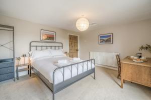 a bedroom with a bed and a table and a desk at Forge End Cottage Middleham in Middleham