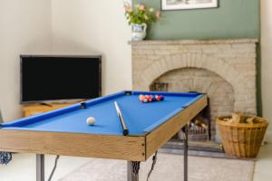 a pool table in a living room with a fireplace at Forge End Cottage Middleham in Middleham +20 photos