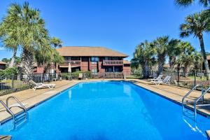 a swimming pool with palm trees in front of a house at Golf Course Views! Couple's Retreat in Diamondhead in Diamondhead