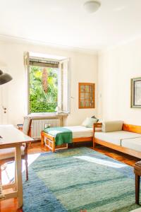 a living room with two beds and a window at Villa dei Muralti - Homestay - Rooms rental in Muralto