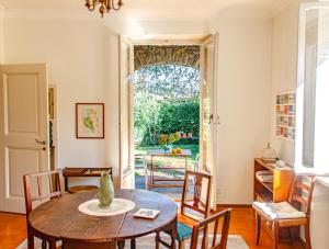 a dining room with a table and chairs and a window at Villa dei Muralti - Homestay - Rooms rental in Muralto