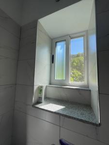 a mirror in a bathroom with a window at eljos house permet in Përmet