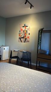 a room with a table and chairs and a painting at Residencial Zoe 101 in Foz do Iguaçu