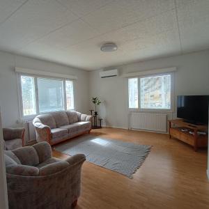 a living room with two couches and a flat screen tv at Villa Green in Kruunupyy