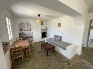 a bedroom with a bed and a table and a desk at Agios Pavlos Studios in Aegiali