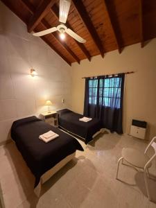 a bedroom with two beds and a ceiling fan at Casa Guemes in Merlo