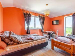 two beds in a room with orange walls at Pokoje Gosia in Puck
