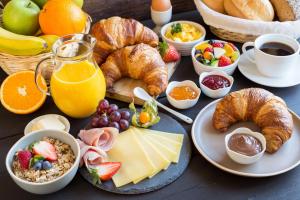 a table with a breakfast of cheese croissants and fruit at B&B beApart in Ieper