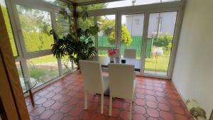 a dining room with a table and chairs and windows at Ferienwohnung Aiubi in Attnang-Puchheim +11 photos