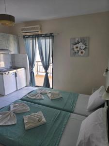 a bedroom with a green bed with towels on it at Nikis studios in Skala Sotiros