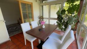 a wooden table and white chairs in a room at Ferienwohnung Aiubi in Attnang-Puchheim
