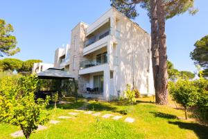 a white house with a tree in the yard at SanPietro Apartments in Draç