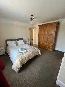 a bedroom with a large bed and a wooden cabinet at Ivanhoe Home from Home in Freshwater