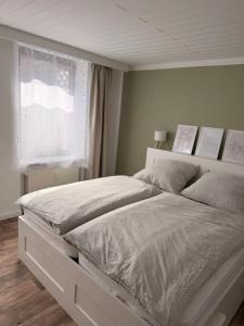 a white bed in a bedroom with a window at Ferienwohnung Börnecker Landruhe in Börnecke