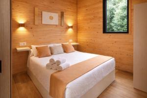 a bedroom with a bed with two towels on it at Cabañas Compostela - Cabaña Sarela in Santiago de Compostela