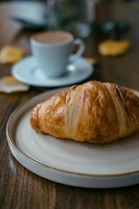 a croissant on a plate with a cup of coffee at Casa Scianna Noto in Noto +15 photos