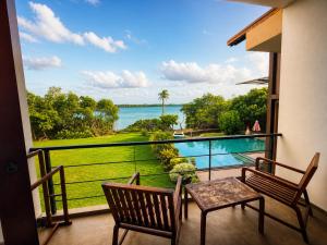a balcony with a table and chairs and a view of the water at Zen Koggala by Sugar Coliving in Habaraduwa Central