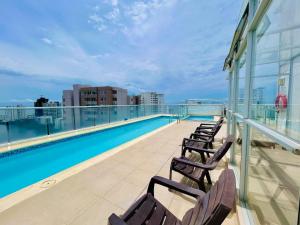 a balcony with chairs and a swimming pool on a building at Cartagena Flat Resort in Cartagena de Indias