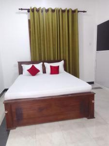 a bed with two red pillows in a room at Sette Stelle in Pahala Maragahawewa