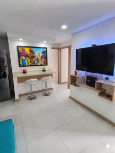 a living room with a large television and two stools at Cartagena Flat Resort in Cartagena de Indias