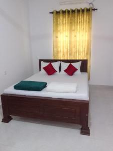 a bed with red and green pillows in a room at Sette Stelle in Pahala Maragahawewa