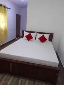 a bed with red pillows in a room at Sette Stelle in Pahala Maragahawewa