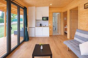 a living room with a couch and a table at Cabañas Compostela - Cabaña Sarela in Santiago de Compostela +5 photos