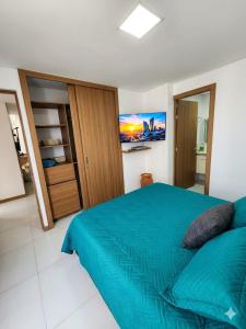 a bedroom with a blue bed and a tv at Cartagena Flat Resort in Cartagena de Indias +15 photos