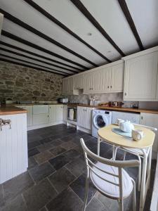 a kitchen with a table and chairs in it at Brook cottage in Brayton Station