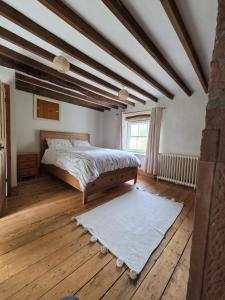 a bedroom with a bed and a wooden floor at Brook cottage in Brayton Station