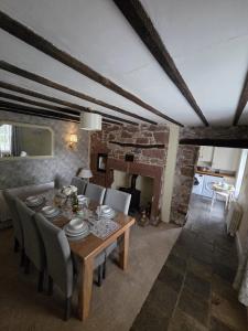 a dining room with a table and chairs and a fireplace at Brook cottage in Brayton Station +5 photos