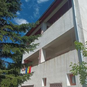 a building with flags on the side of it at Refugiul din Cozieni in Cozieni