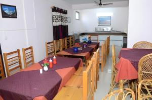 a restaurant with tables and chairs and a kitchen at The himaliyan munros in Rānīkhet