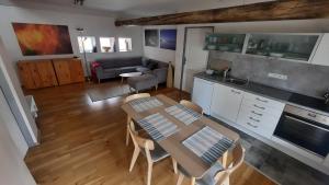 a kitchen and living room with a table and chairs at Apartmán Franz Josef in Hošťka