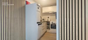 a kitchen with white cabinets and a refrigerator at Ramfjord Apartment 2 in Tromsø