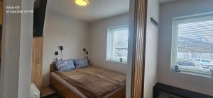 a small bedroom with a bed and a window at Ramfjord Apartment 2 in Tromsø