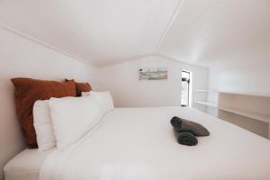 a bedroom with a white bed with a shoe on it at Alpine Chalet - views, fire-pit, central, cosy in Wanaka