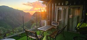 a balcony with a table and chairs with a view at Green Discovery's Birds' Nests in Henrietta