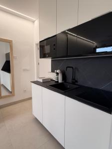 a kitchen with white cabinets and a black counter top at El Rincón in Pozoblanco